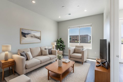 A living room with a couch, chair, and a painting on the wall.