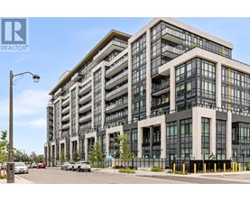 A modern multi-story building with a glass facade and a street view in front.