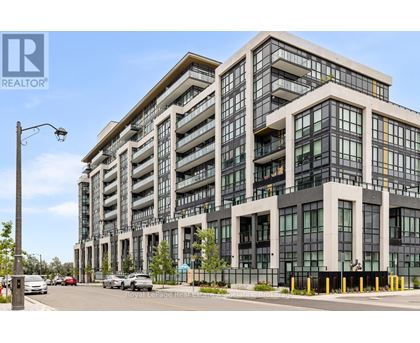 A modern multi-story building with a glass facade and a street view in front.