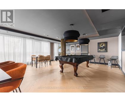 A living room with a black table and orange chairs.