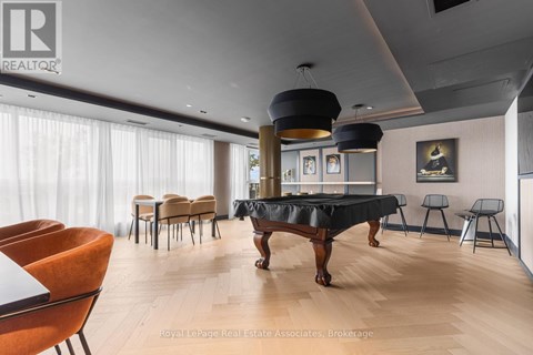 A living room with a black table and orange chairs.