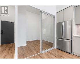 A kitchen with a refrigerator and a sliding glass door.