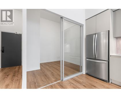 A kitchen with a refrigerator and a sliding glass door.