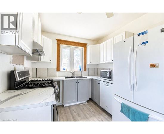 A kitchen with white appliances and wooden cabinets.