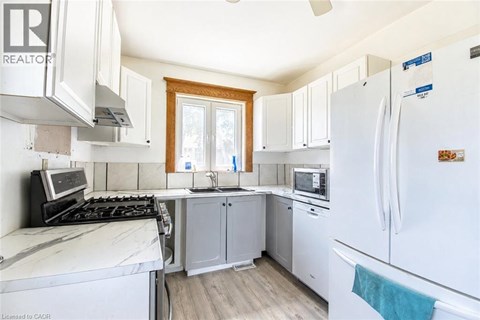 A kitchen with white appliances and wooden cabinets.