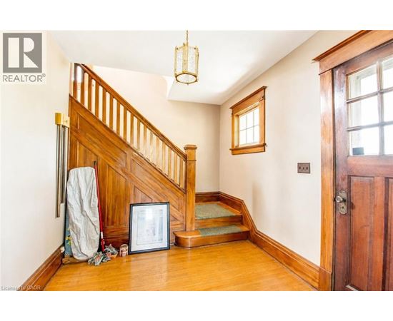 A wooden staircase with a chandelier hanging above it.