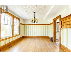 A room with wooden floors and striped wallpaper.