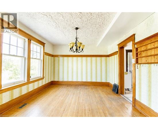 A room with wooden floors and striped wallpaper.