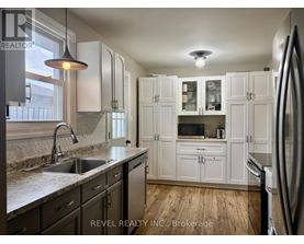 A kitchen with white cabinets and a stainless steel refrigerator.