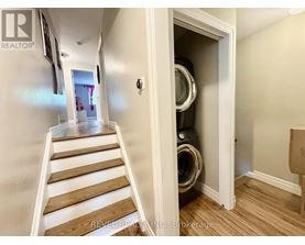 A hallway with a staircase leading to a laundry room.