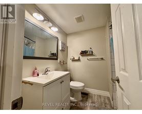 A bathroom with a sink, toilet, and mirror.