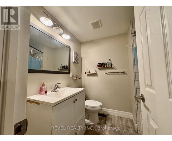 A bathroom with a sink, toilet, and mirror.