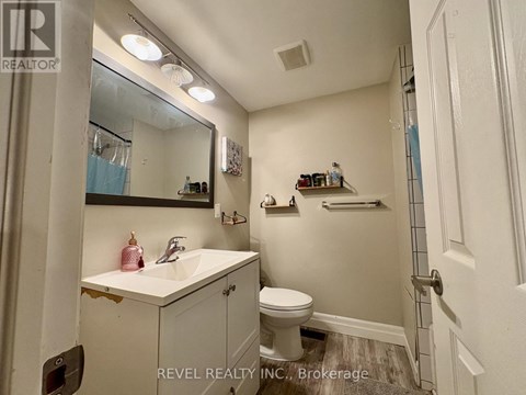 A bathroom with a sink, toilet, and mirror.