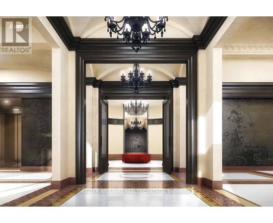A hallway with a chandelier and a red bench.
