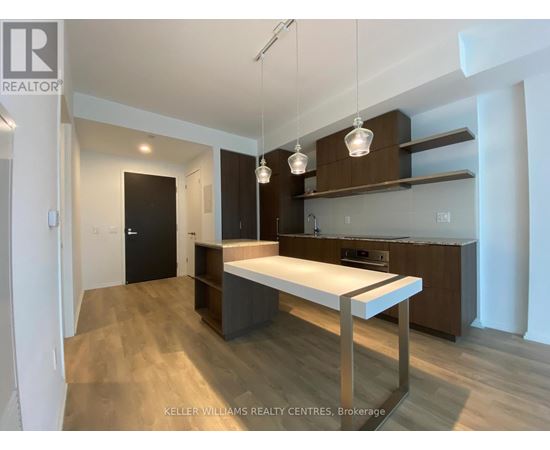 A modern kitchen with a long white island in the middle.