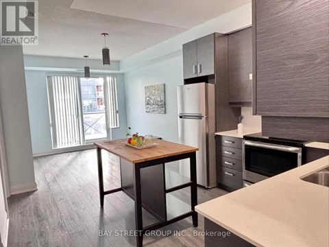 A kitchen with a table and chairs in front of a refrigerator.