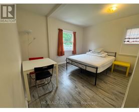 A bedroom with a bed, desk, and chair.