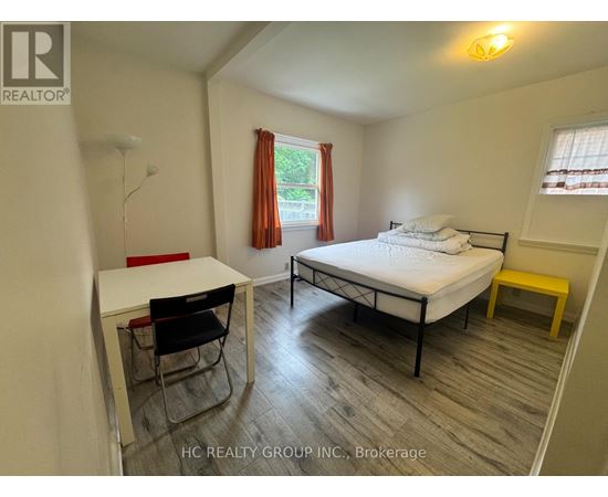 A bedroom with a bed, desk, and chair.