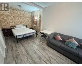 A bedroom with a bed, a couch, and a chair.