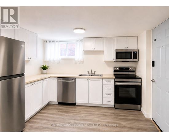 A kitchen with white cabinets and a stainless steel refrigerator.