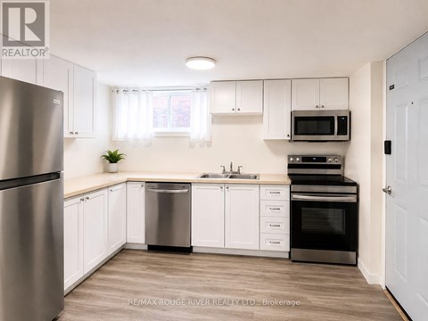 A kitchen with white cabinets and a stainless steel refrigerator.
