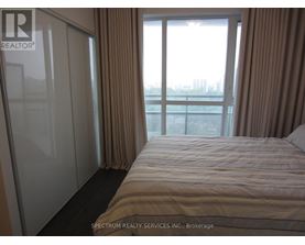 A bedroom with a large bed and a view of the city.