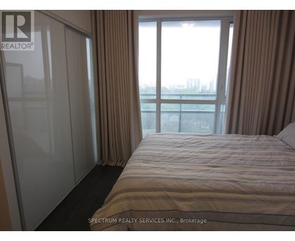 A bedroom with a large bed and a view of the city.