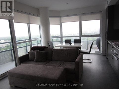 A living room with a brown couch and a television.