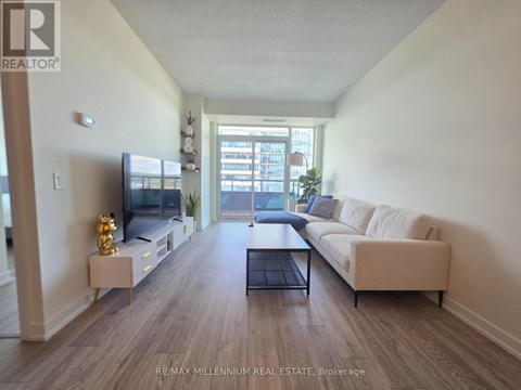 A spacious living room with a white sofa and a television.
