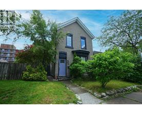 A house with a blue door is surrounded by greenery.