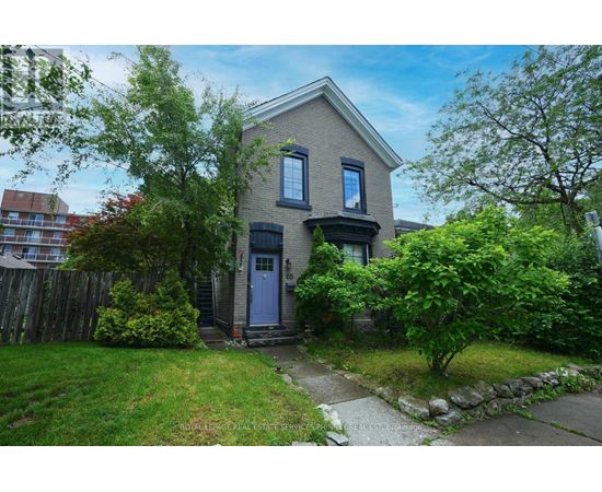 A house with a blue door is surrounded by greenery.