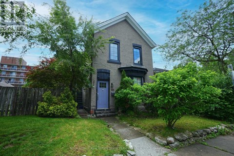 A house with a blue door is surrounded by greenery.