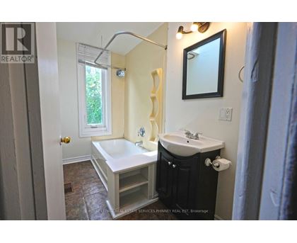 A bathroom with a tub, sink, and mirror.