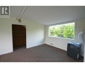 A room with a window and a door leading to a hallway.