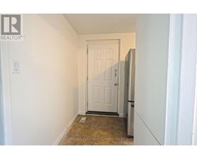 A white door is in a white hallway.
