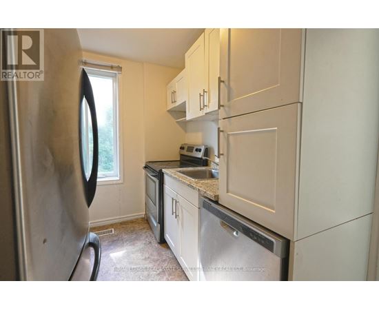 A kitchen with a refrigerator, microwave, and oven.