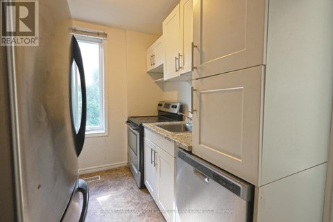 A kitchen with a refrigerator, microwave, and oven.