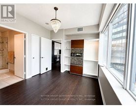 A spacious room with a chandelier and a large window.