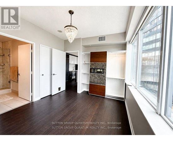 A spacious room with a chandelier and a large window.