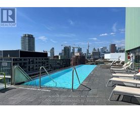 A pool on a rooftop with chairs around it.