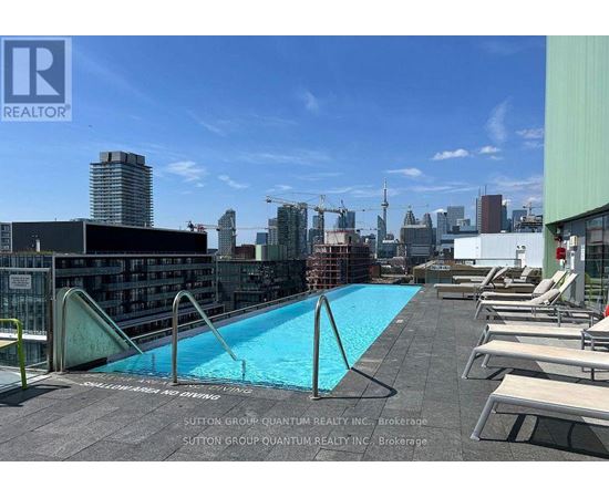 A pool on a rooftop with chairs around it.