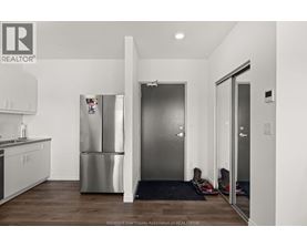 A kitchen with a refrigerator and a sink.