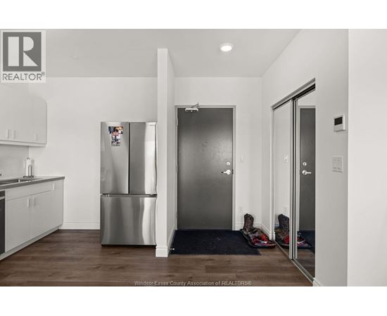 A kitchen with a refrigerator and a sink.