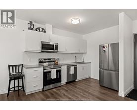A kitchen with white cabinets and stainless steel appliances.