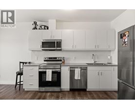 A kitchen with white cabinets and a black stove top oven.