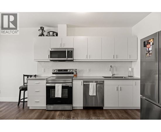 A kitchen with white cabinets and a black stove top oven.