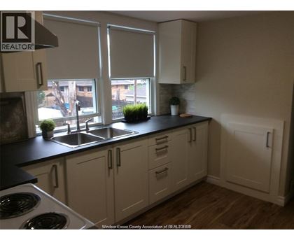 A kitchen with white cabinets and a black countertop.