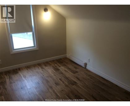 A room with a window and wooden flooring.