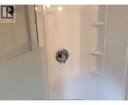 A white door with a silver handle in a bathroom.