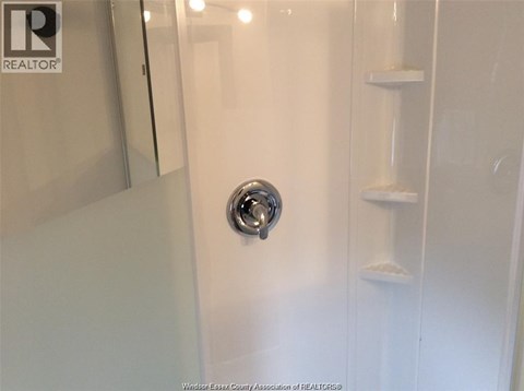 A white door with a silver handle in a bathroom.